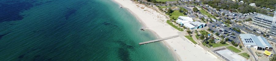 Busselton Jetty busselton jetty in the ocean next to white sand beach