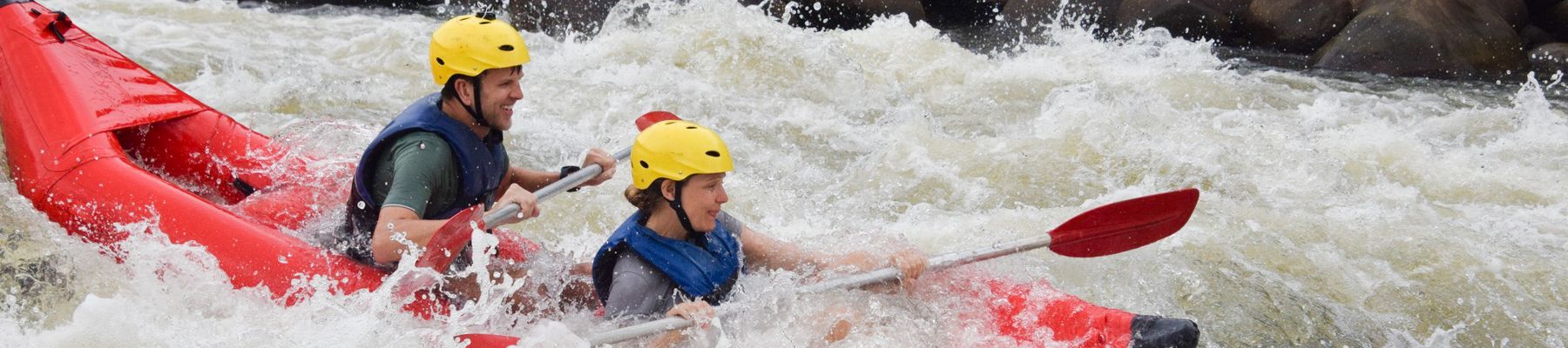 two people going down a rapid in a kayak