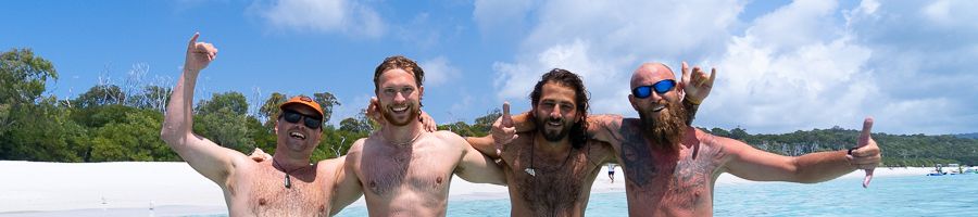 four guys having fun in the water at the beach
