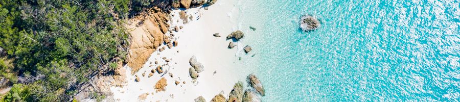 aerial view of white sand and blue water in the whitsundays